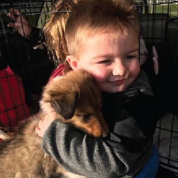 Boy hugging puppy